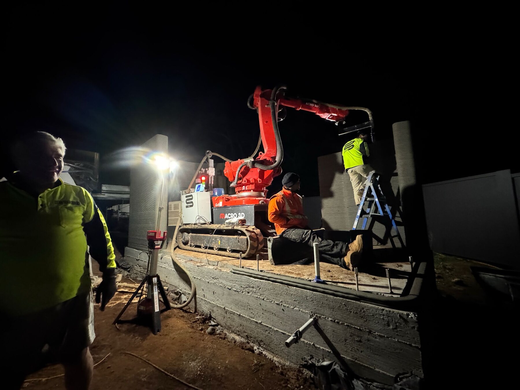 Concrete 3D printing robot working on site at night